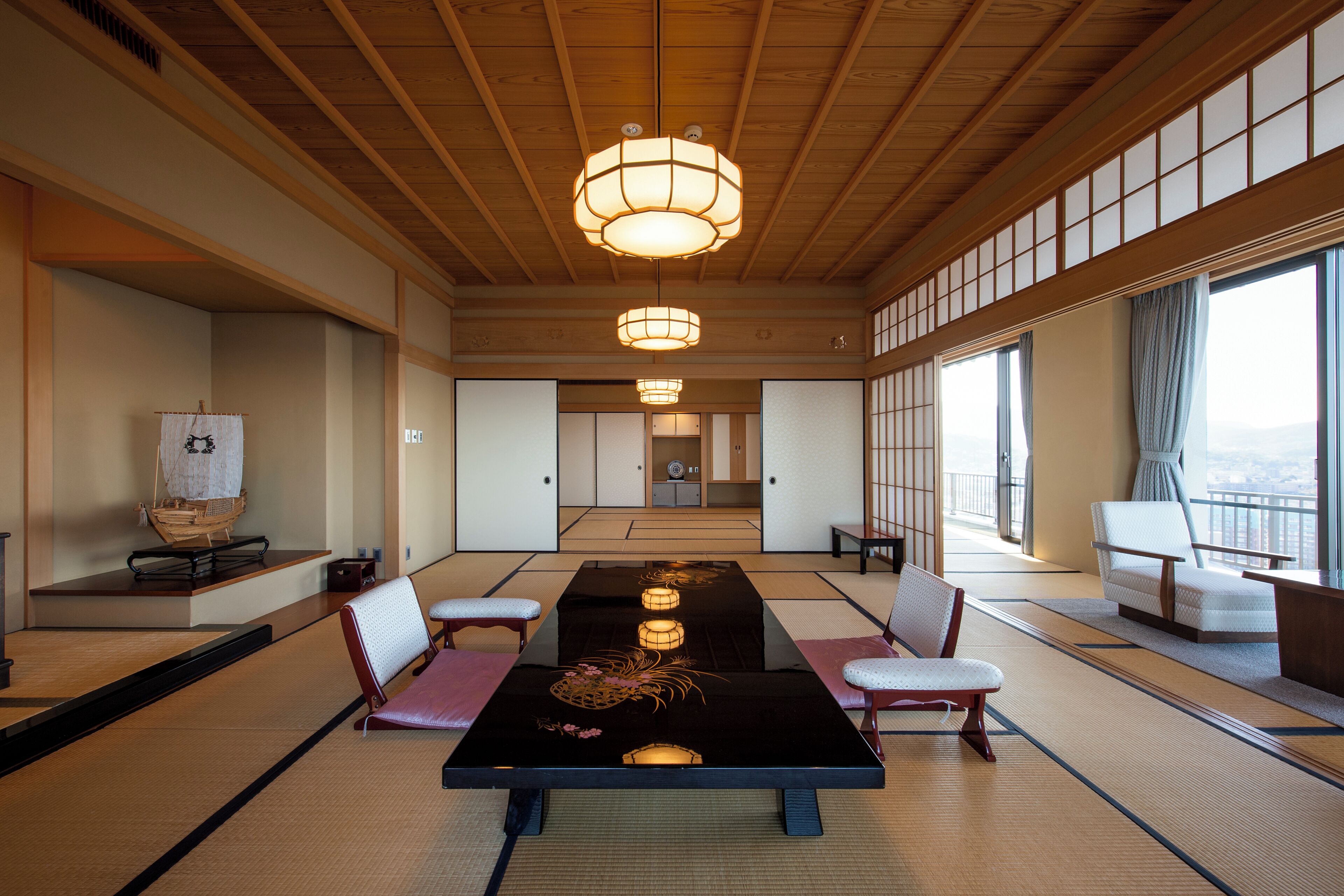 Una habitació tradicional japonesa amb tatamis, taules baixes i portes corredisses.
