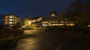 A traditional Japanese building with multiple floors and a prominent pagoda-style roof, surrounded by well-maintained gardens and a paved driveway. - Ginrinsou (Otaru)