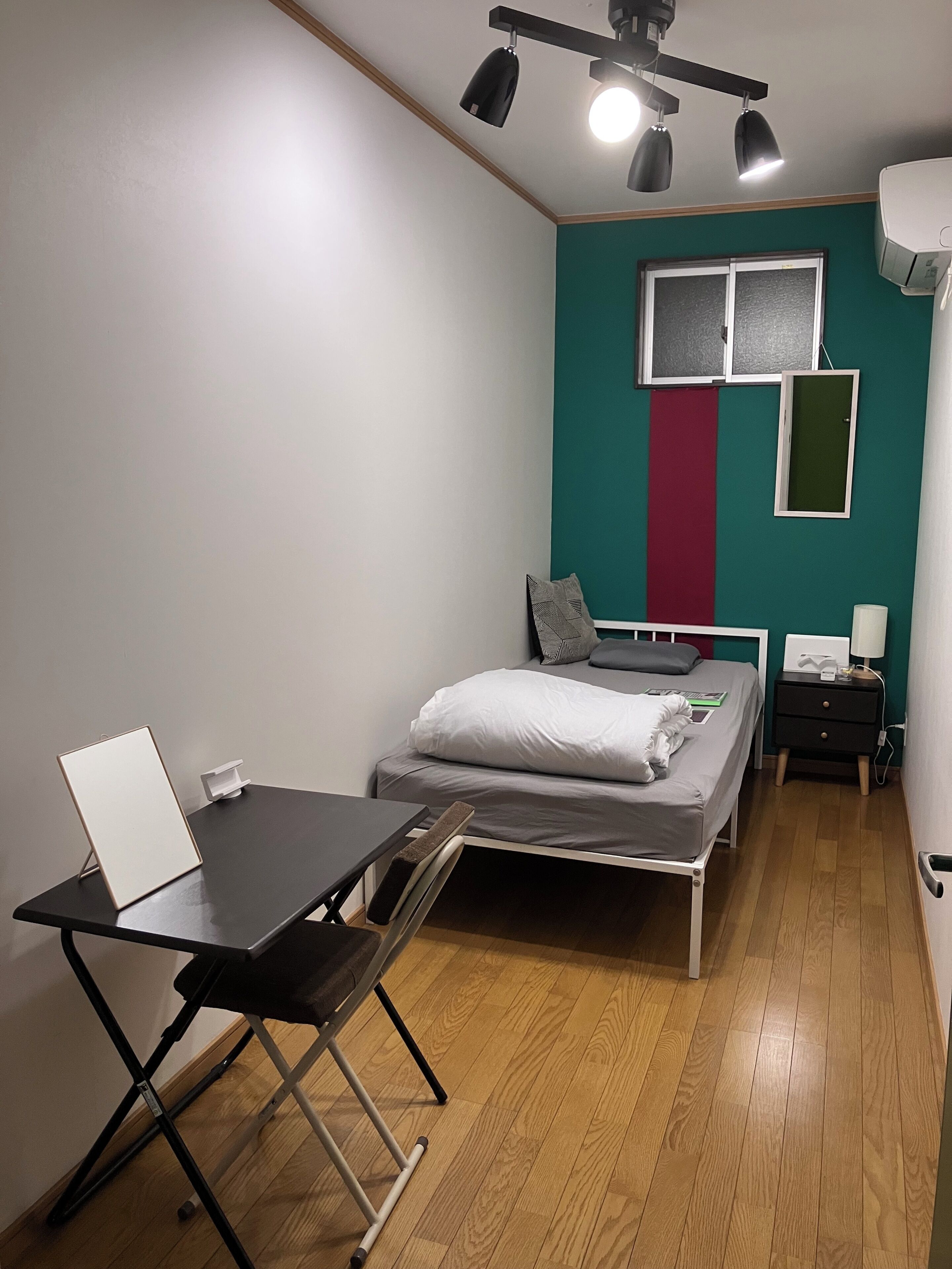 A compact room with a bed, a desk, and a chair.