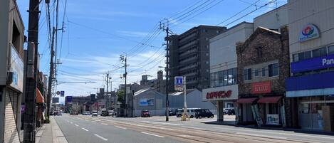 A street view with buildings, a clear sky, and power lines.