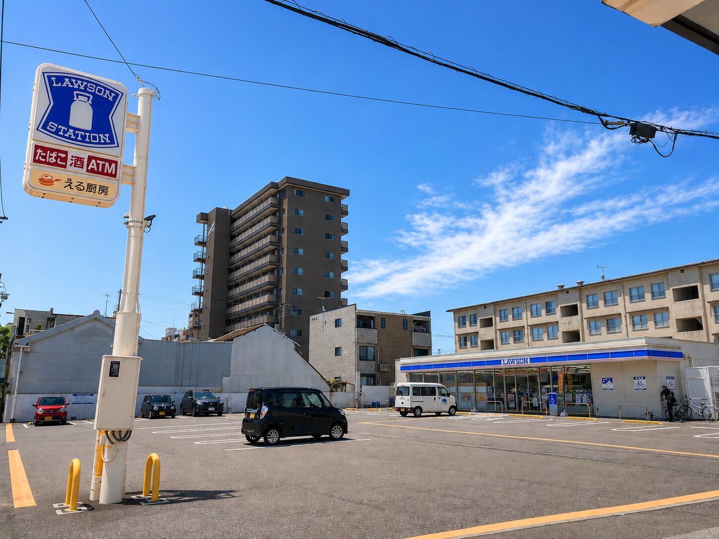 A Lawson station with a parking lot, a multi-story building, and a gas station.