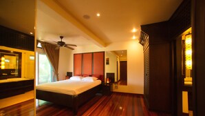 Habitación de hotel con una cama grande, piso de madera, ventilador de techo y vistas al exterior.