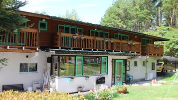 Stunning chalet with a spacious balcony and large windows, offering a serene garden view.