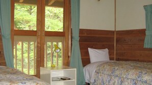 A room with two beds, wooden beams, a window with curtains, and a small table with a lamp. - Hirotani Pension & Lodge (Hara)