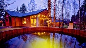 A wooden cabin with a porch and a swimming pool. - Winiec Family Houses (Winiec)