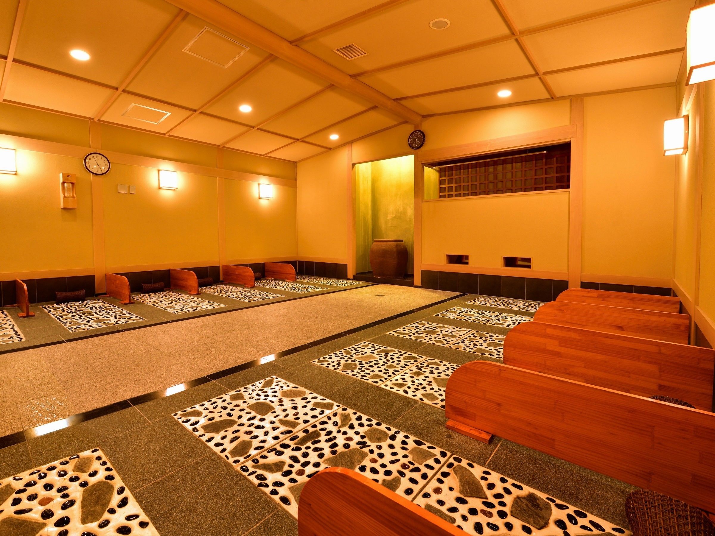 Ein Zimmer mit Tatami-Matten, Holzbänken und traditioneller japanischer Gestaltung.
