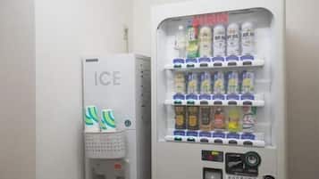A vending machine with multiple beverage options and a separate ice dispenser.