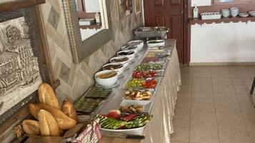 A buffet setup with various food items and utensils.