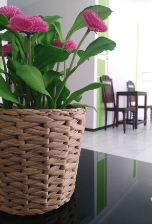 A woven basket with pink flowers on a reflective surface. - StayWonderful01 Kota Laksamana (Malacca City)