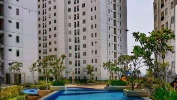 Zona de piscina con varias pistas de natación, rodeada de altos edificios residenciales y algo de vegetación.