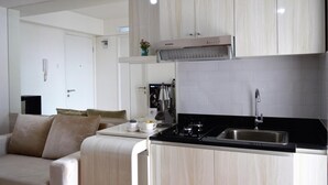 Una cocina moderna con encimera negra, pileta de acero inoxidable y muebles de cocina blancos.