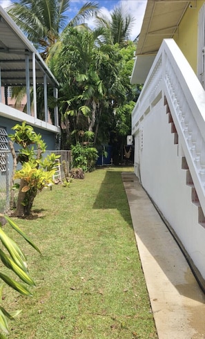 Stroll through lush gardens to a modern building with a flat roof and staircase.