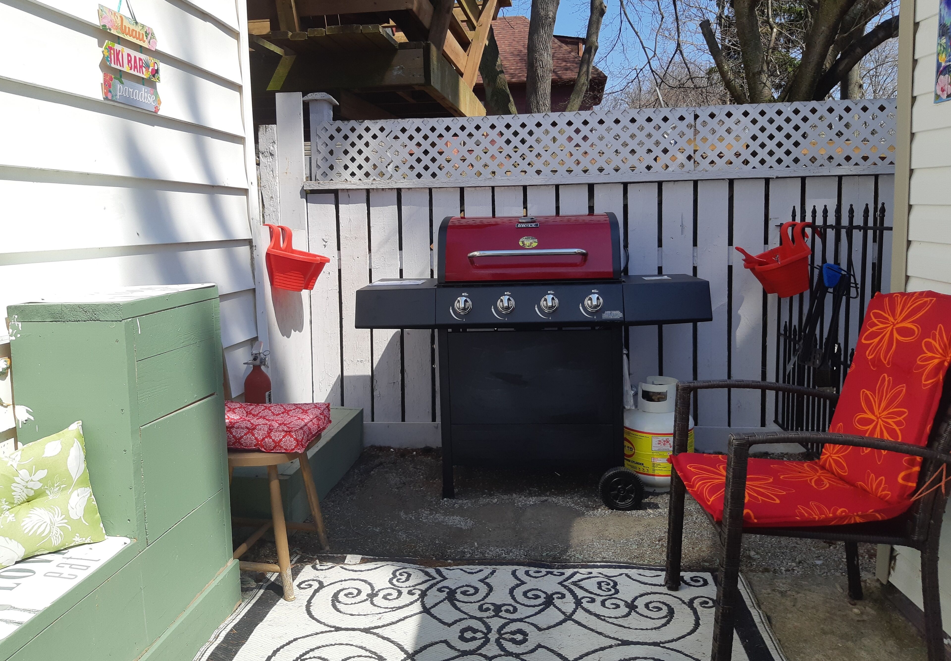Une terrasse avec un barbecue, une chaise et une petite table.