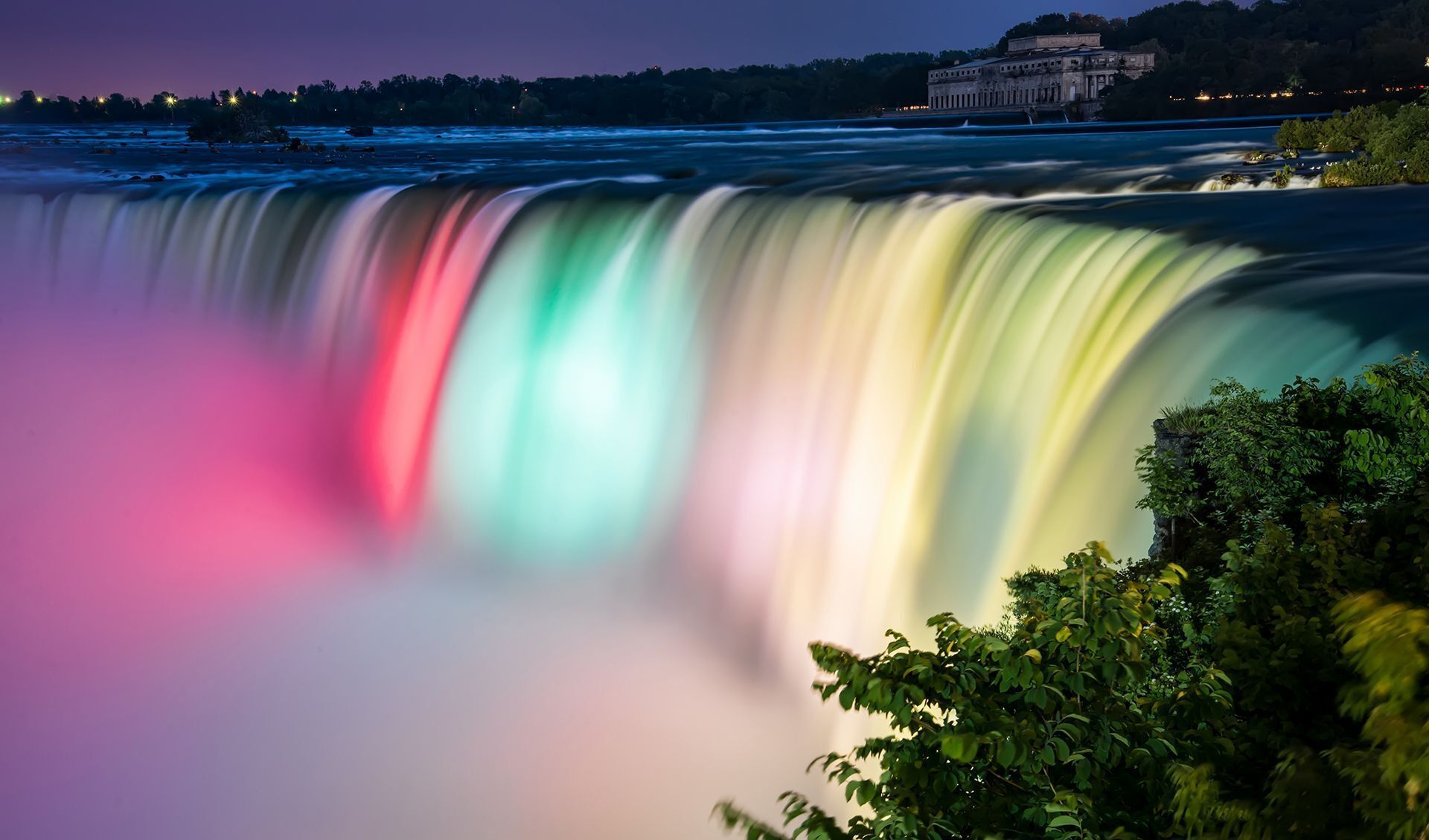 A waterfall with a building in the background.