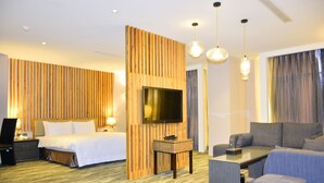 A hotel room with a bed, a TV, a sofa, and a small table. - Ali Mountain Oriental Pearl International Hotel (Zhongpu)