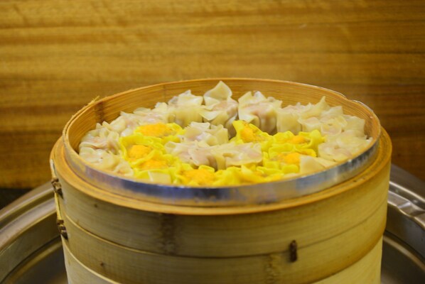 A bamboo steamer with food inside.