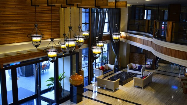 A spacious lobby with multiple seating areas, a large vase, and hanging lanterns. - Ali Mountain Oriental Pearl International Hotel (Zhongpu)