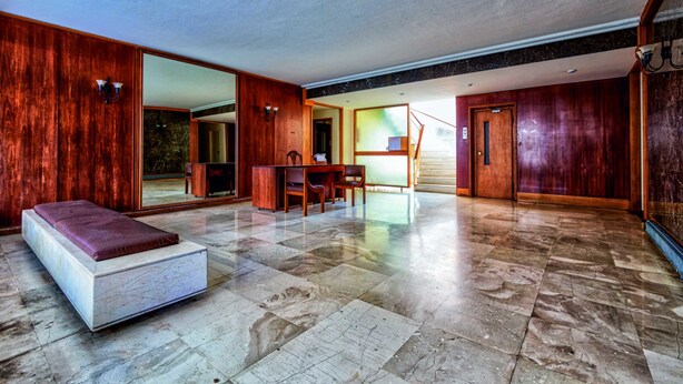 A spacious room with a large bed, a wooden desk, and a dining area. - Groovy Apartment by the Sea with Garden (Alimos)