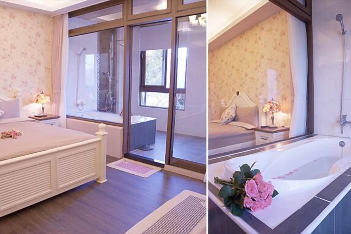 Quarto com cama grande, janela e banheiro com banheira.
