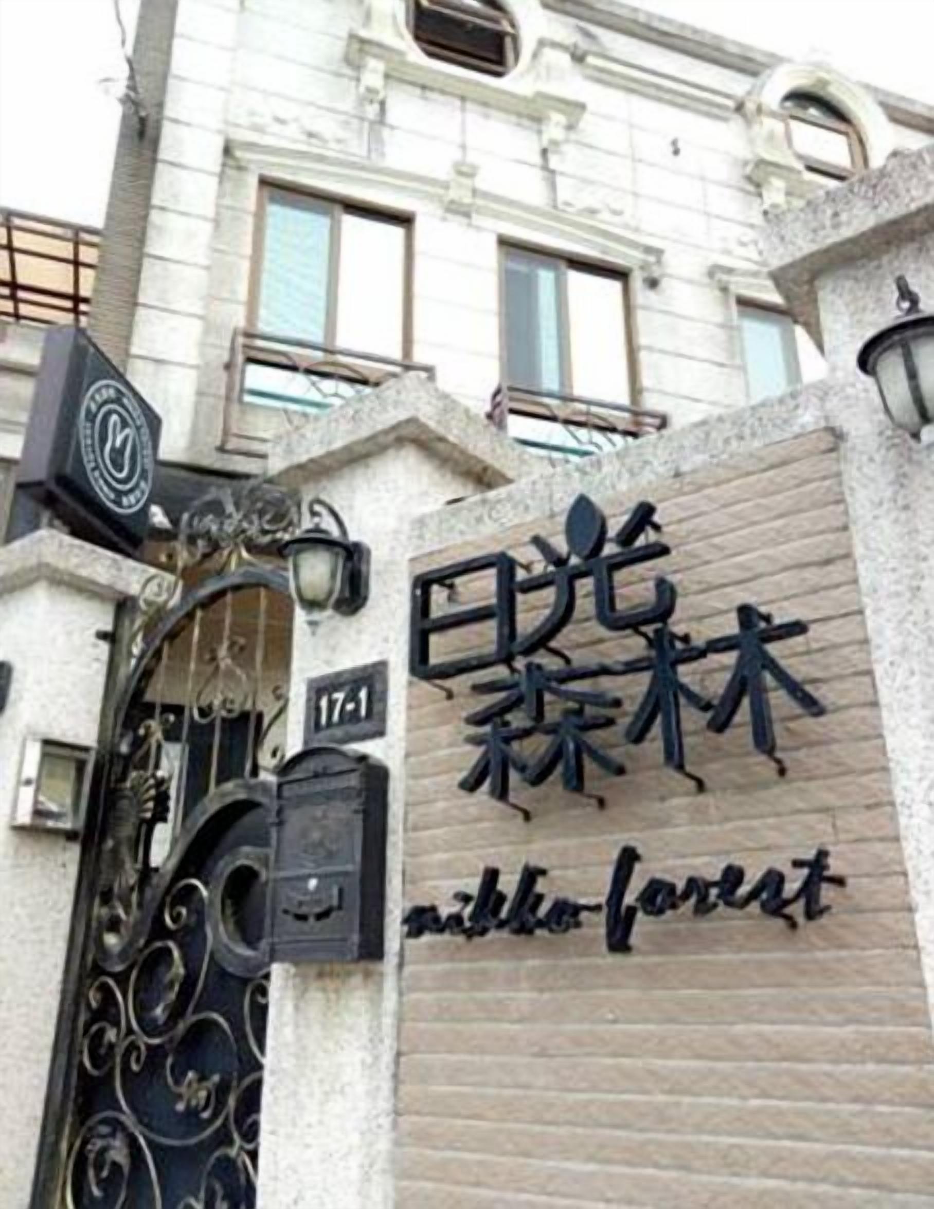 Entrada de un edificio con un letrero que dice "Nikko Forest" y el número "17-1" sobre la puerta.