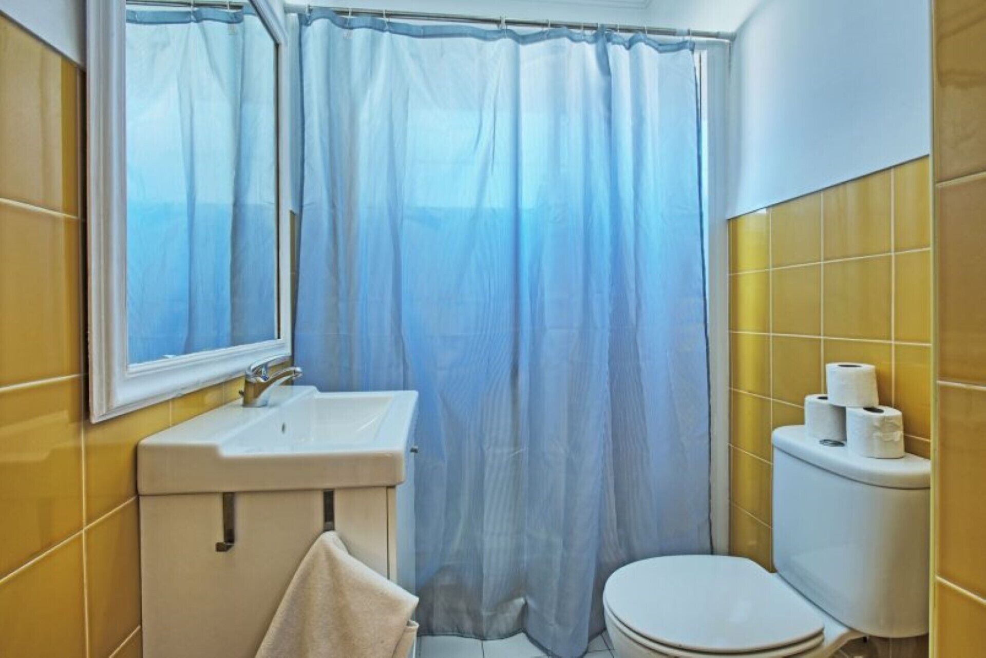 A bathroom with a sink, toilet, and a window with a view.
