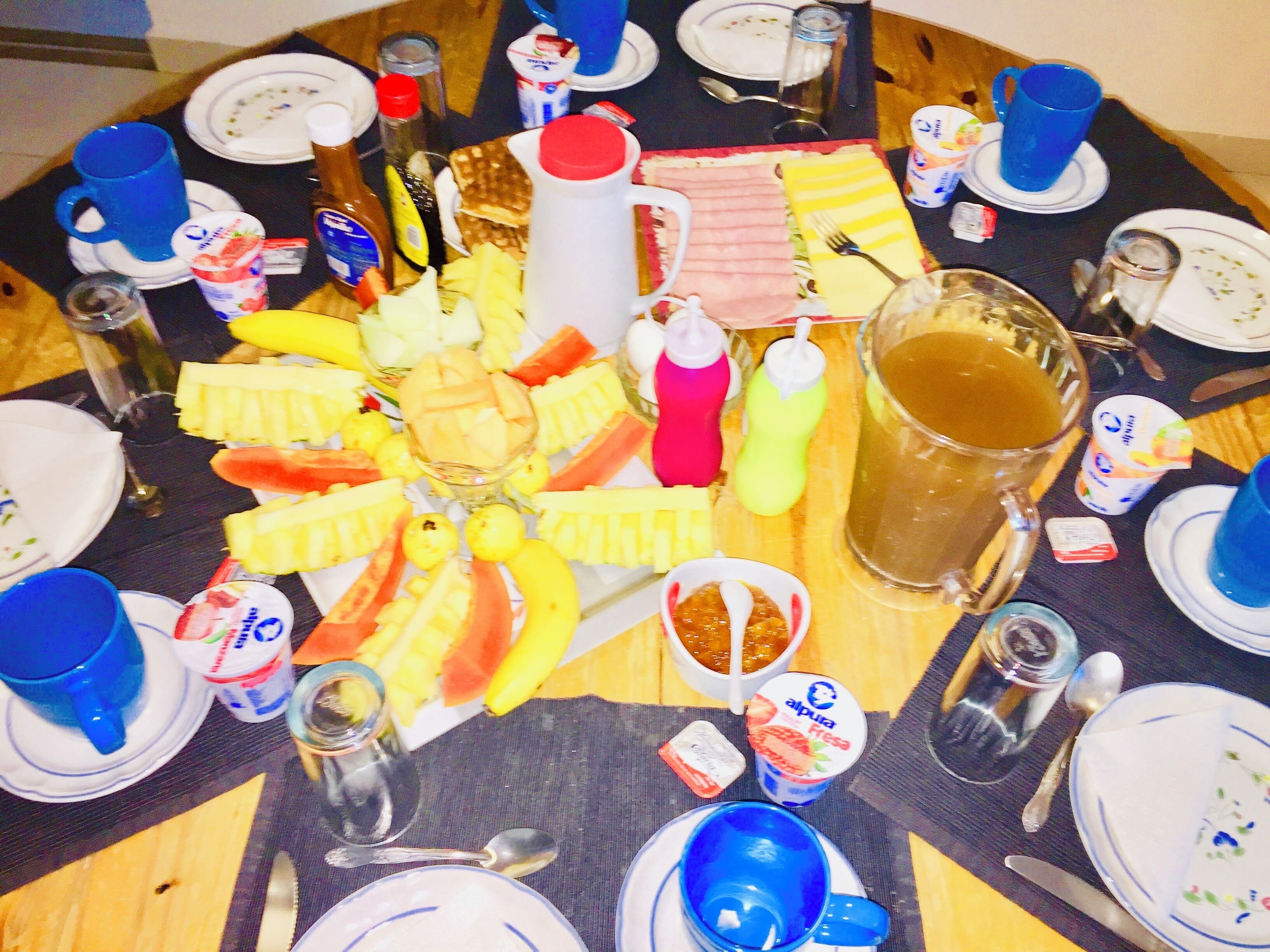 Taula rodona amb diferents plats, begudes i condiments.