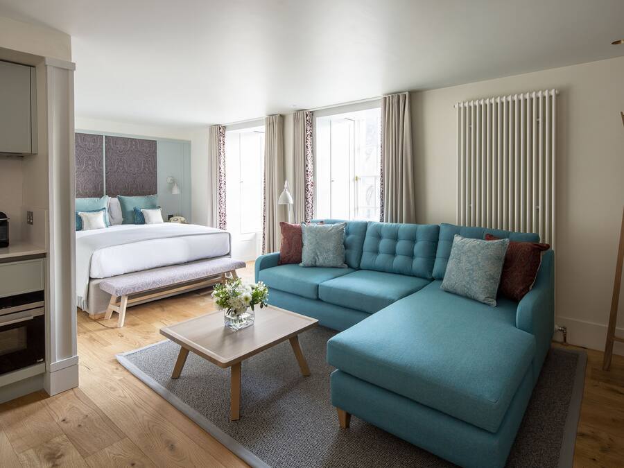 A modern living room with a sofa, a coffee table, and a bed.