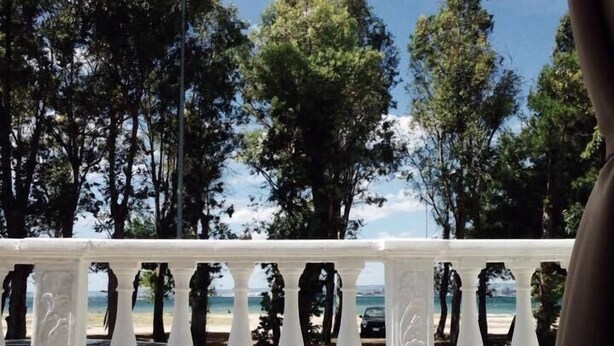 A balcony with a white balustrade overlooking a beach. - SunWine Bed & Breakfast (Taranto)