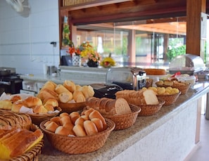 Mostrador de buffet con panes y pasteles varios.