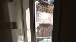 Una habitación con puerta de vidrio corredera que da a un balcón exterior.