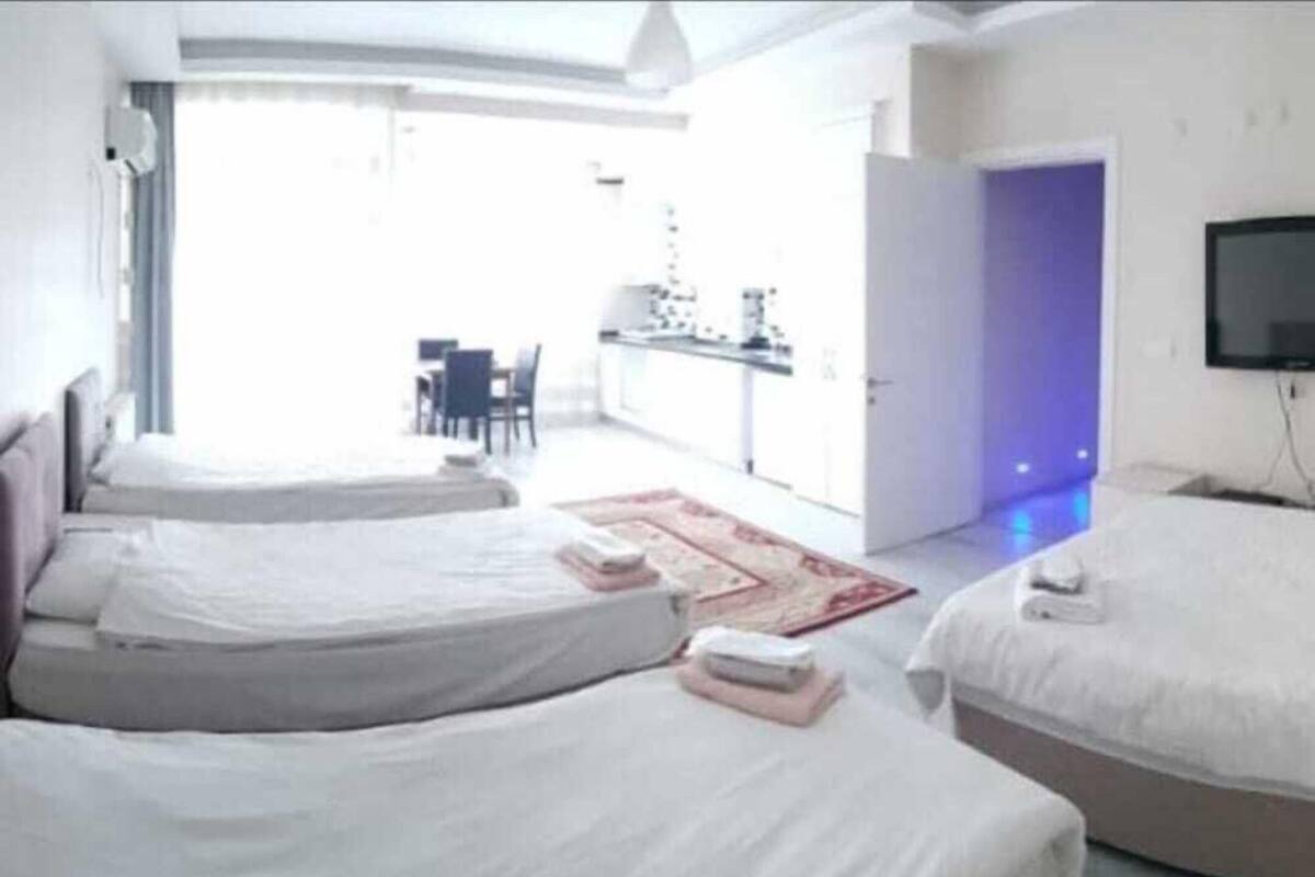 A hotel room with two beds, a small desk, a chair, and a TV.