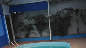 Piscina com piso azulejado e borda azul.