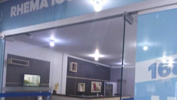 Uma área de recepção de hotel com divisória de vidro, balcão de atendimento e um balcão.