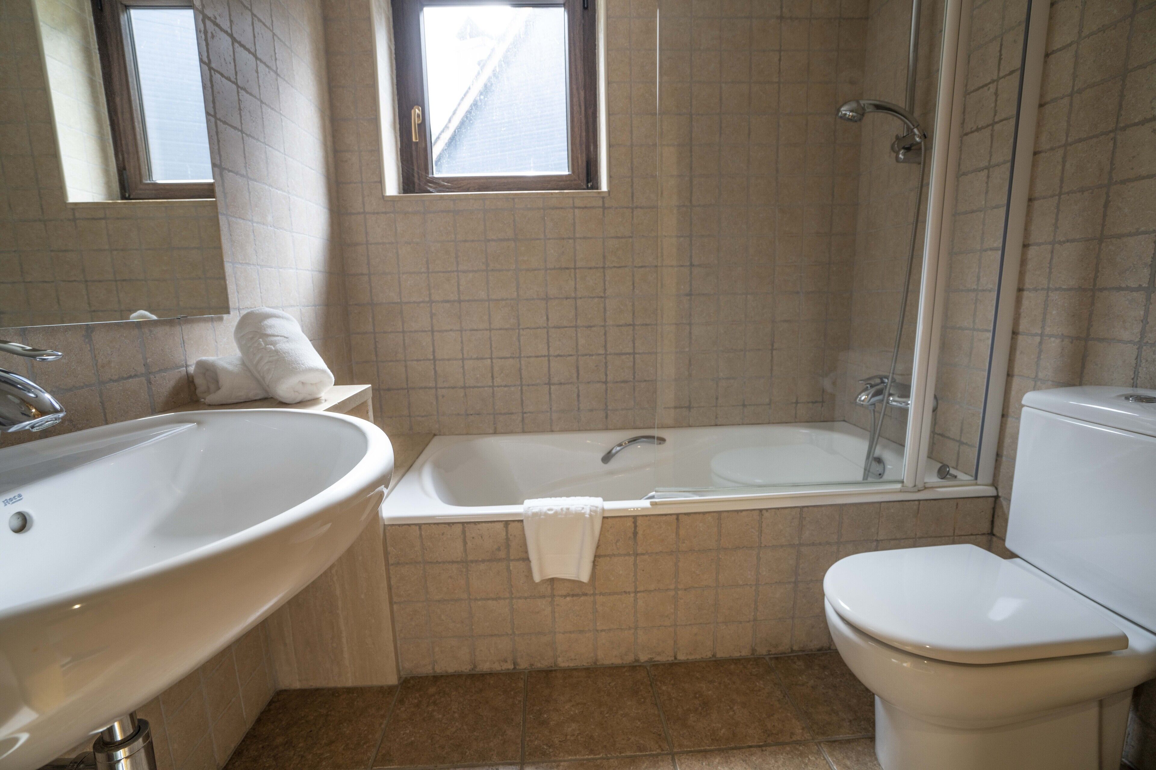 A bathroom with a large sink, bathtub, and toilet.
