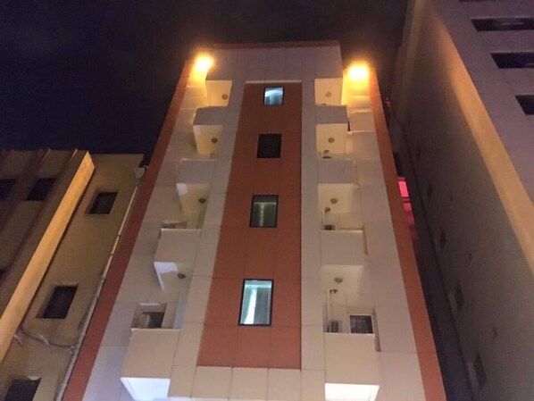 A multi-story building with a central atrium, balconies, and a red accent wall. - Bianca Residence (Izmir)