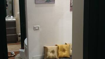 Ein Flur mit einer Bank, einem Bild an der Wand und einem Fliesenboden.