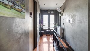 A narrow hallway with wooden flooring, a view of boats on water through a large window, and a door labeled "D 301-301". - OYO 685 Am Bed Hostel (Bangkok)