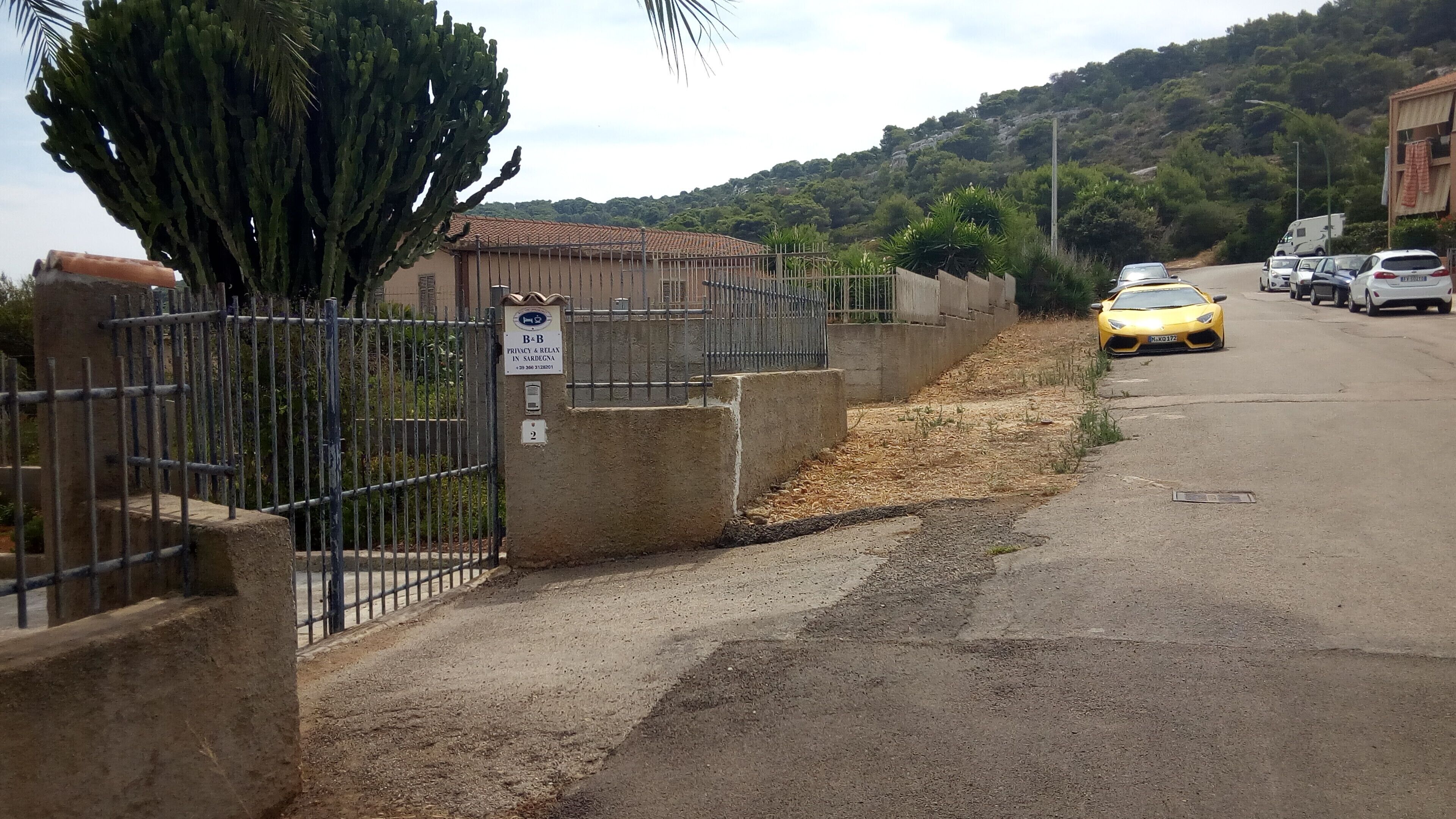 Una proprietà recintata con un cartello che indica privacy e relax in Sardegna.