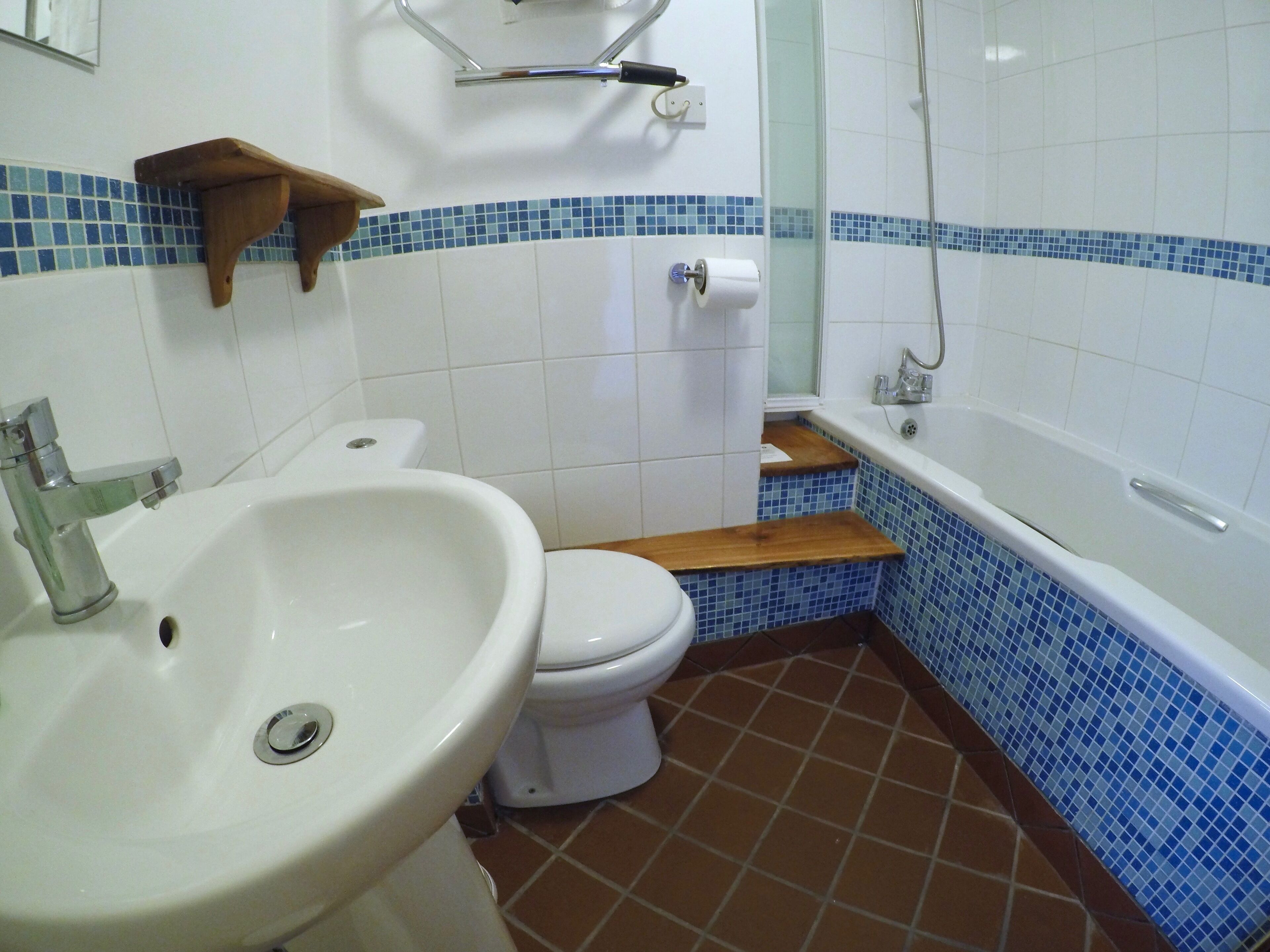 A bathroom with a white sink, toilet, and bathtub.