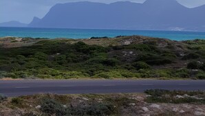 Eine Küstenstraße mit Blick auf Berge und das Meer.