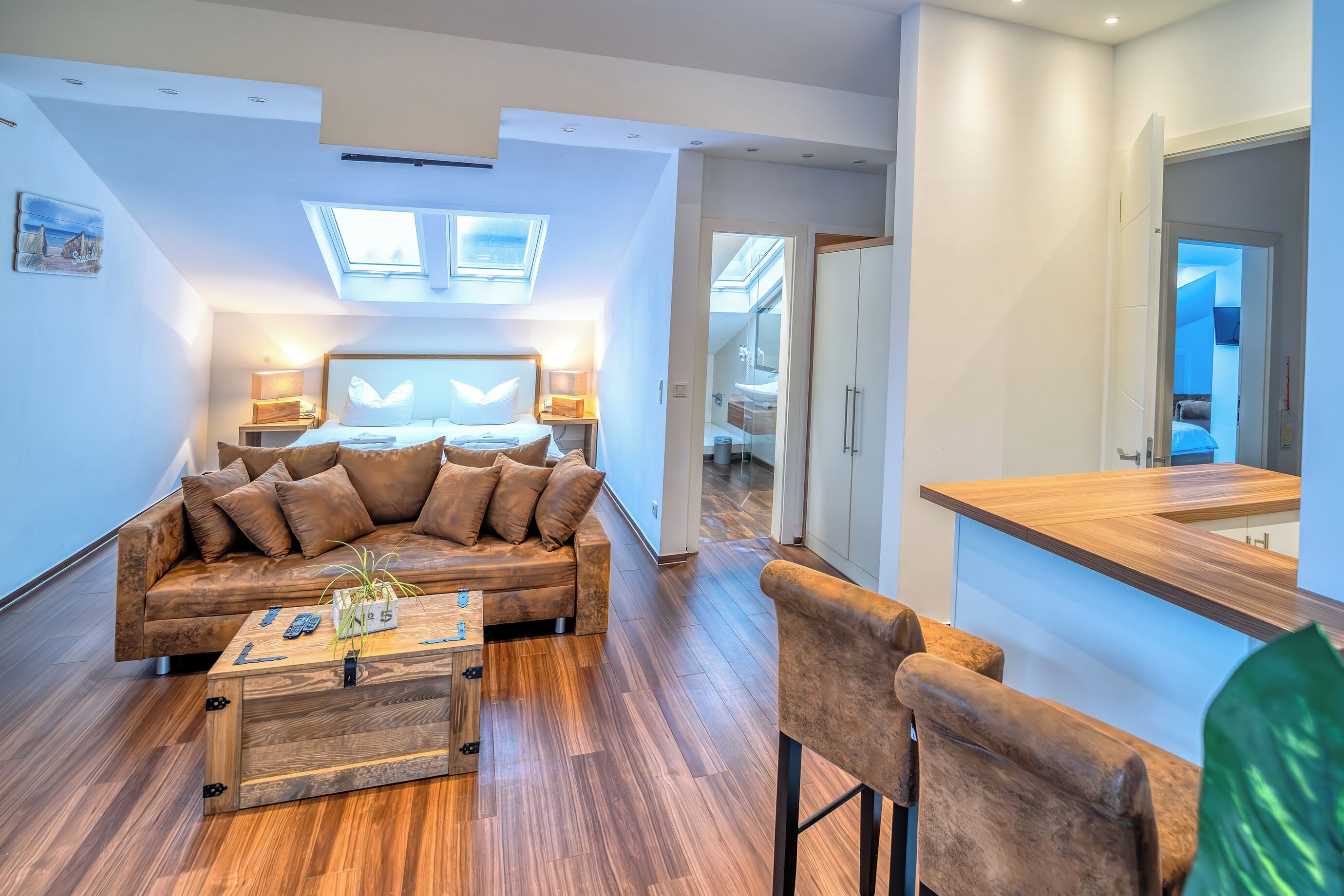 A modern living room with a wooden coffee table, a brown leather sofa, and a wooden dining table.