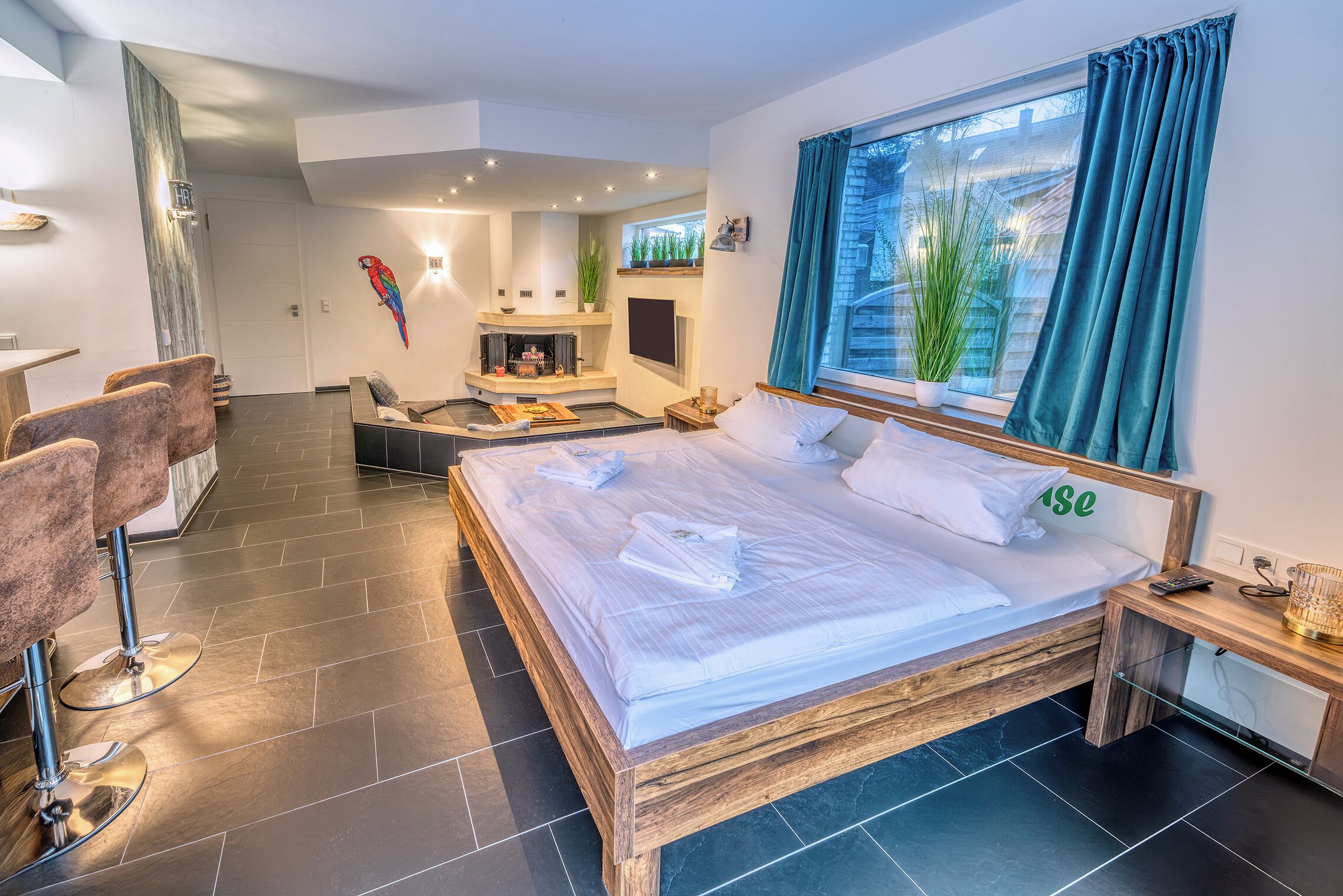A modern bedroom with a large bed, a desk, and a seating area.