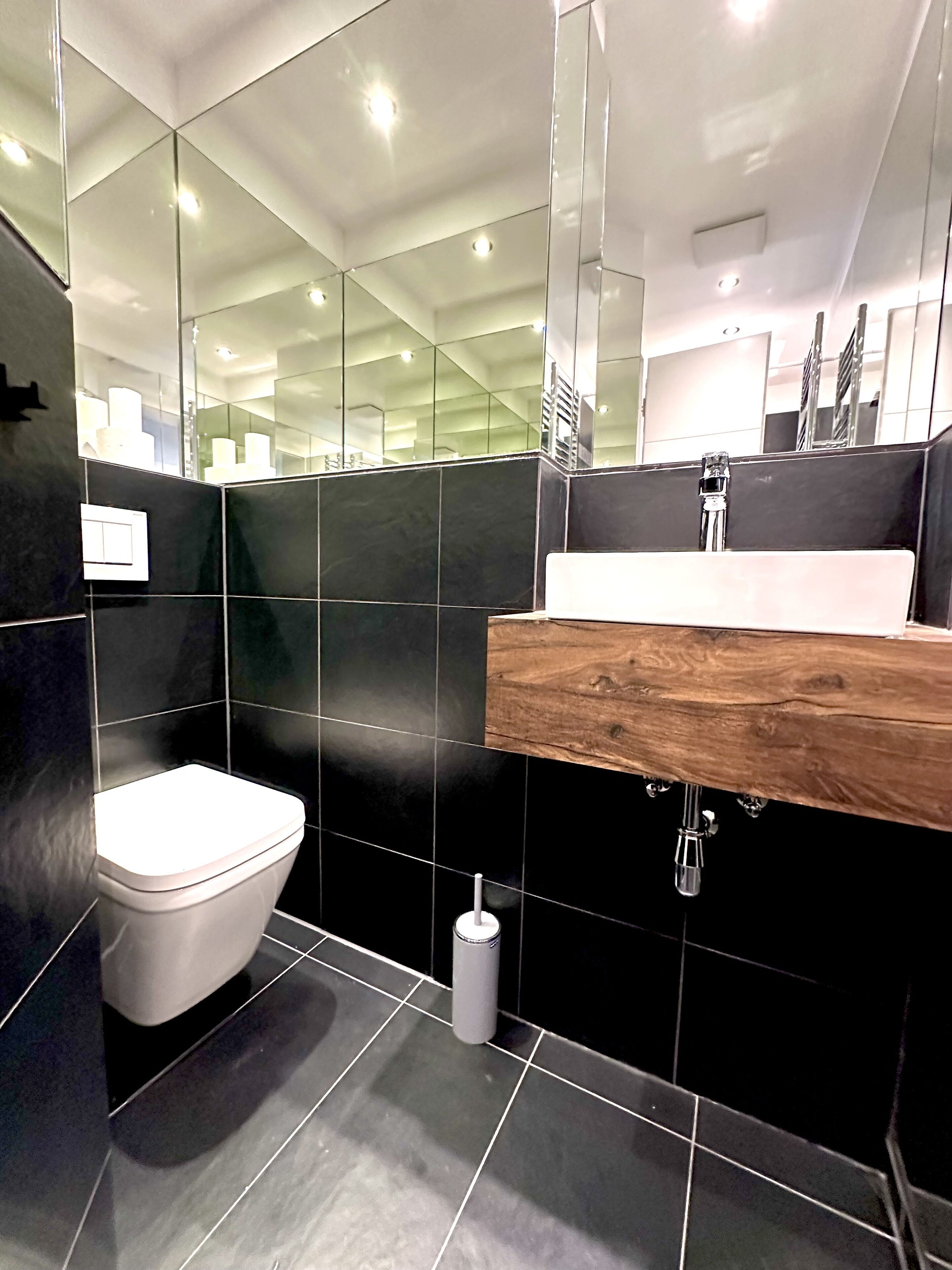 Un bagno moderno con il water, lavandino e specchio.