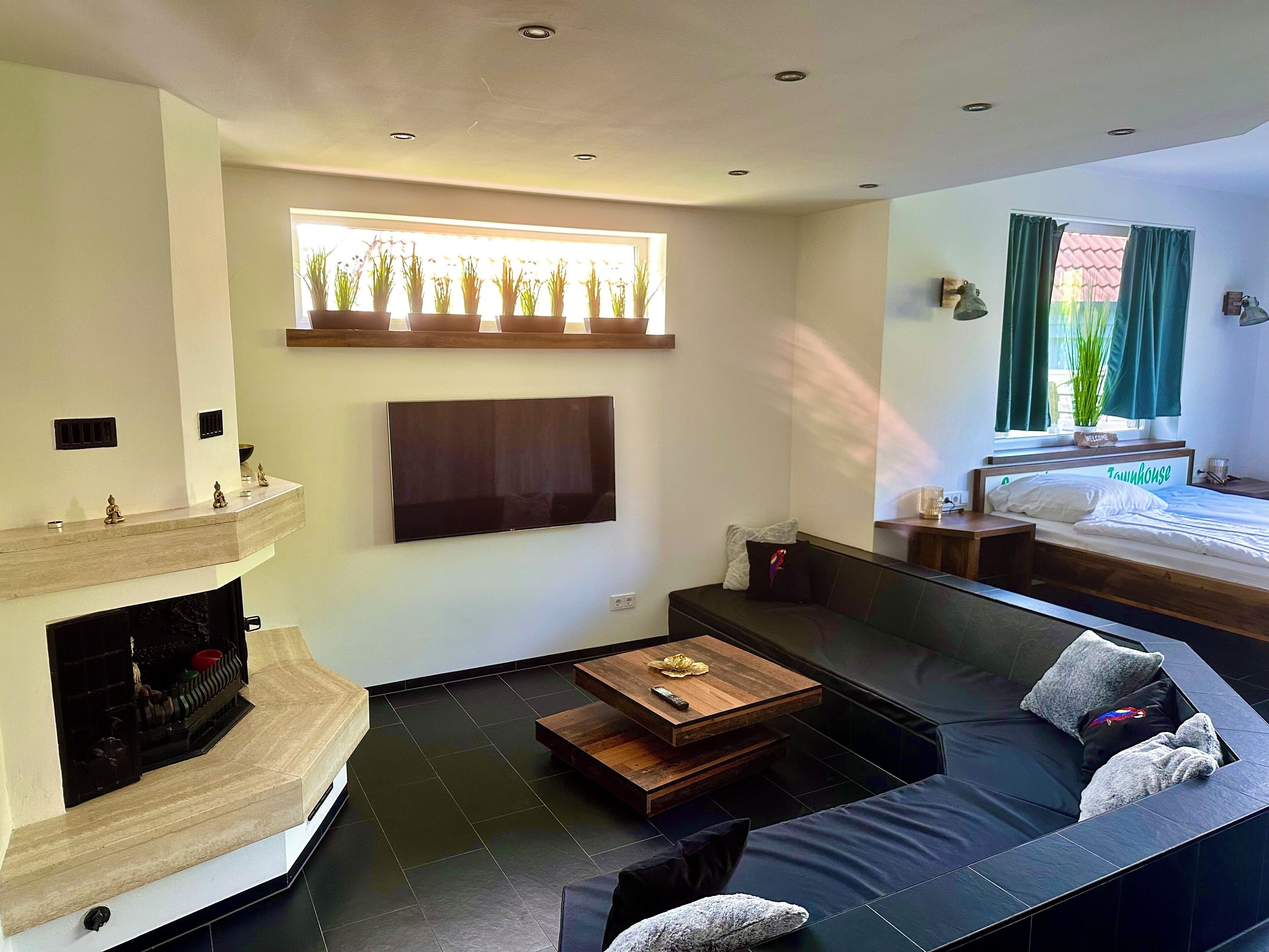 Ein modernes Wohnzimmer mit Kamin, Flachbildfernseher, Sofa und Couchtisch.