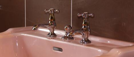 Un lavabo de salle de bain doté de deux robinets chromés et d’un modèle à commande unique.