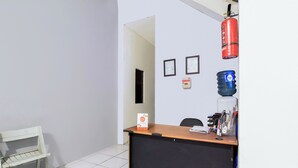 Una reception con un erogatore d'acqua, certificati incorniciati al muro e un estintore.