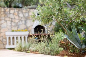 Stroll through the serene garden, surrounded by lush plants and a tranquil stone wall.