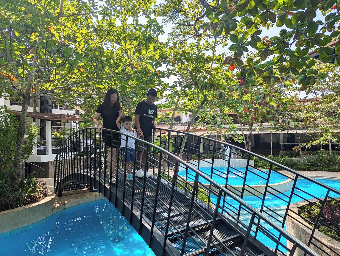 Una zona de piscina con una escalera metálica que lleva a una plataforma.