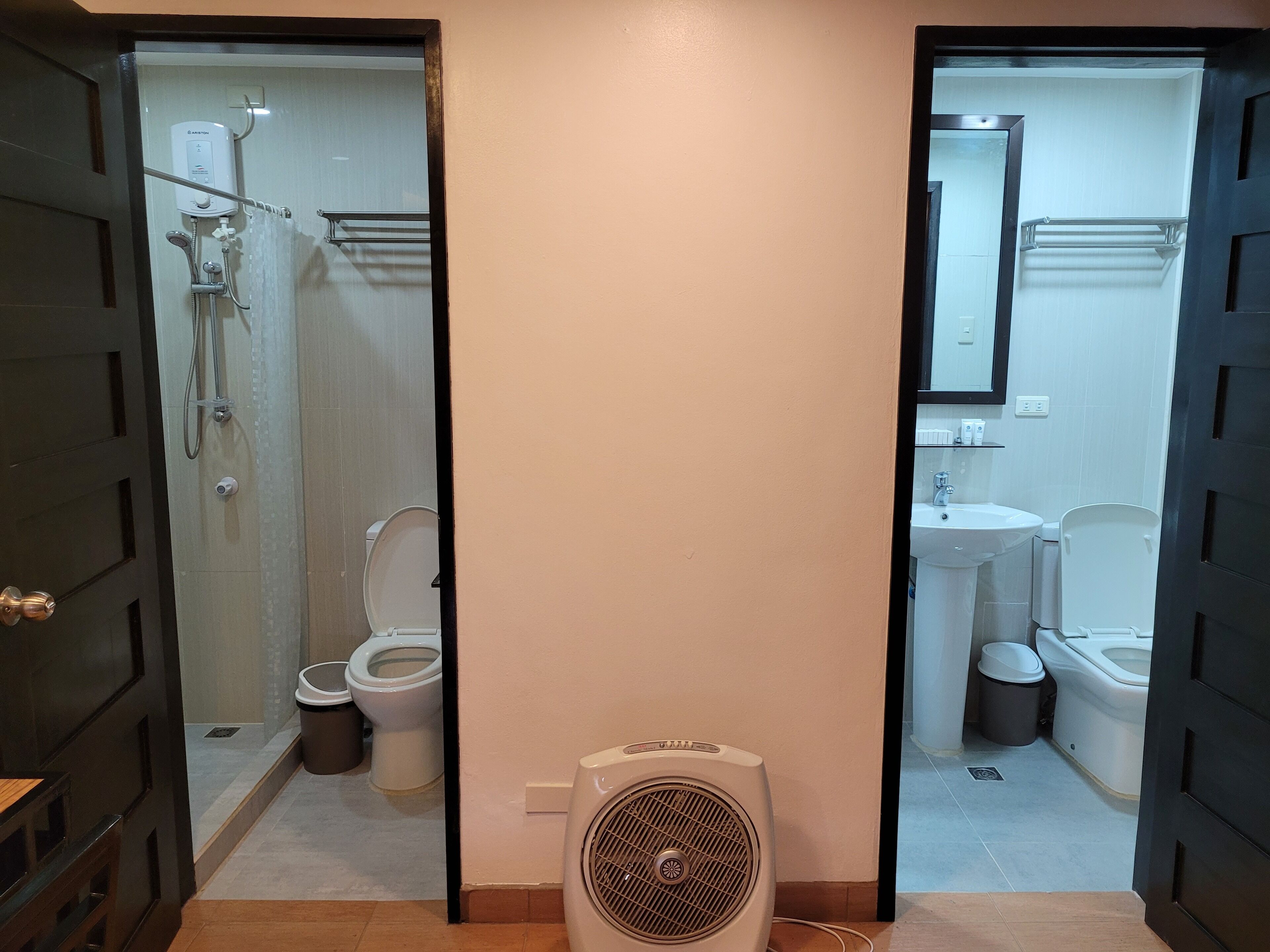 A bathroom with a shower, toilet, sink, and a fan.