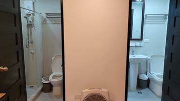 A bathroom with a shower, toilet, sink, and a fan.